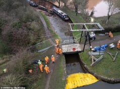 Trabalhadores tentam resgatar três barcos estreitos arrastados para as profundezas pelo colapso do canal que deixou os proprietários fugindo para salvar suas vidas na calada da noite