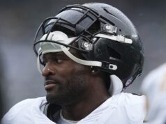 A estrela do Pittsburgh Steelers, DK Metcalf, balança com um torcedor durante uma luta lateral