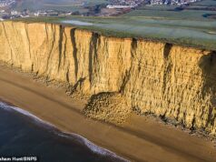 Momento em que os caminhantes da praia são forçados a correr para salvar suas vidas enquanto uma enorme queda de rochas desmorona do penhasco de Dorset de 150 pés